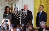 Le président Reuven Rivlin allume la menorah de Hanoukka , en présence du président américain Barack Obama, de Michelle Obama, et de Nechama Rivlin, à la Maison Blanche, le 9 décembre 2015. (Crédit : capture d'écran YouTube/The White House)
