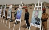 Des militaires se tenant derrière les portraits des victimes de l'attaque du 15 janvier lors d'une cérémonie de commémoration sur la place de la Nation à Ouagadougou le 25 janvier, 2016, en hommage aux victimes du 15 Janvier attaque qui a tué 30 personnes (Crédit : AFP / Ouoba AHMED)