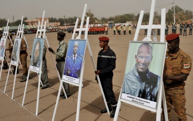 Des militaires se tenant derrière les portraits des victimes de l'attaque du 15 janvier lors d'une cérémonie de commémoration sur la place de la Nation à Ouagadougou le 25 janvier, 2016, en hommage aux victimes du 15 Janvier attaque qui a tué 30 personnes (Crédit : AFP / Ouoba AHMED) Des militaires se tenant derrière les portraits des victimes de l'attaque du 15 janvier lors d'une cérémonie de commémoration sur la place de la Nation à Ouagadougou le 25 janvier, 2016, en hommage aux victimes du 15 Janvier attaque qui a tué 30 personnes (Crédit : AFP / Ouoba AHMED)