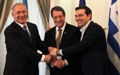 Le président chypriote, Nicos Anastasiades (au centre), le Premier ministre israélien Benjamin Netanyahu (à gauche) et le Premier ministre grec, Alexis Tsipras se serrant la main lors de leur rencontre au palais présidentiel à Nicosie, à Chypre, le 28 janvier 2016 (Crédit : POOL/AFP / Yiannis Kourtoglou)