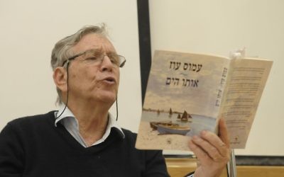 Le célèbre auteur israélien Amos Oz qui lit l'un de ses livres à Tel Aviv (Crédit : Tomer Neuberg / Flash90)