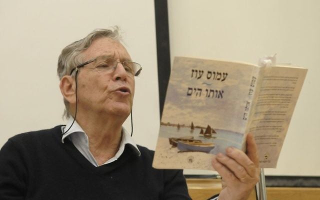 Le célèbre auteur israélien Amos Oz qui lit l'un de ses livres à Tel Aviv (Crédit : Tomer Neuberg / Flash90)