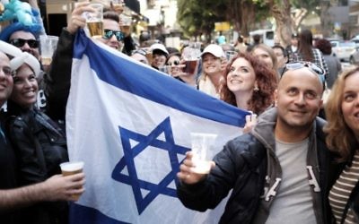 Des Israéliens assistent à une fête de rue au Bar Simta sur la rue Dizengoff à Tel-Aviv le 15 janvier 2016, dans le bar où deux Israéliens ont été tués et plusieurs autres blessés dans une fusillade le 1er janvier 2016. (Crédit : Tomer Neuberg / FLASH90)