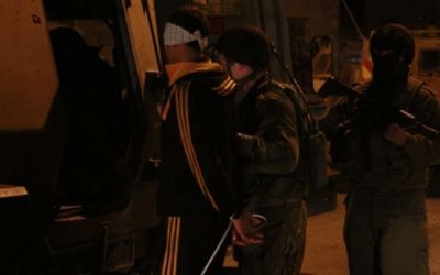 Des soldats embarquent l'un des suspects à l'arrière d'un Zeev, un grand véhicule blindé de transport de personnes, à Qalqilya le 14 janvier 2016. Le commandant des soldats, Lt. Col. Nimrod Cibulski, leur a fait éloigner l'adolescent palestinien de sa famille avant de lui attacher les mains et de lui bander les yeux, afin d'épargner au père du suspect la vision de son fils attaché, selon Cibulski. (Crédit : Judah Ari Gross/Times of Israel)