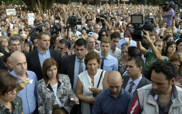 La foule se rassemble autour de Sara Garfunkel (au centre), la mère du procureur argentin Alberto Nisman, pendant une veillée aux chandelles pour le premier anniversaire de la mort mystérieuse de son fils, à Buenos AIres, le 18 janvier 2016. (Crédit : AFP Photo/Eitan Abramovich)