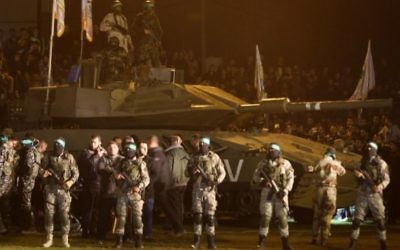Des membres palestiniens de la branche armée du Hamas rassemblés autour d'un faux char israélien le 31 janvier 2016, en hommage aux Gazaouis morts dans l'effondrement d'un tunnel. (Crédit : AFP / MAHMUD HAMS)