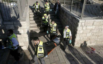 Les secouristes portant les corps de deux terroristes palestiniens tués lors d'un attentat à la porte de Damas, à l'extérieur de la Vieille Ville de Jérusalem, le 3 février 2016 (Crédit : Ahmad Gharabli / AFP)