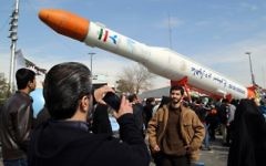 Des Iraniens prennent des photos d'une réplique de la fusée Simorgh, capable de lancer des satellites, pendant les célébrations du 37ème anniversaire de la République islamique, à Téhéran, le 11 février 2016. (Crédit : AFP/Atta Kenare)