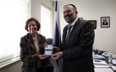 Beate Klarsfeld, reçoit une carte d'identité israélienne des mains d'Aryeh Deri, le 15 février 2016 (Crédit : AFP / THOMAS COEX)