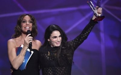 La chanteuse auteur franco-israélienne Yael Naim (à droite), aux côtés de l'animatrice des Victoires de la Musique Virginie Guilhaume après avoir reçu sa récompense d'artiste féminine de l'année lors des 31èmes Victoires de la Musique, au Zénith de Paris de 12 février 2016. (Crédit : Bertrand Guay/AFP)