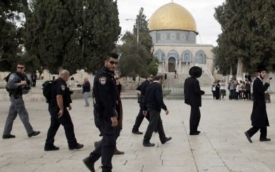 Des Juifs religieux sous la protection de la police israélienne lors d'une visite au mont du Temple dans la vieille ville de Jérusalem, le 27 octobre 2015. (Crédit : Ahmad Gharabli/AFP)