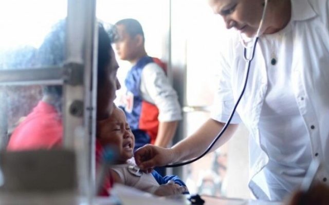 Des membres de l'équipe médicale d'IsraAID soignent les personnes touchés par le typhon. (Crédit : IsraAID/Nufar Tagar)