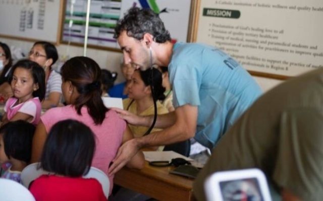 Des membres de l'équipe médicale d'IsraAID soignent les personnes touchés par le typhon. (Crédit : IsraAID/Nufar Tagar)