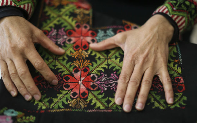 Une femme bédouine montre l'objet créé par une femme de "Broderie du désert : association pour l'amélioration pour les femmes" dans la ville bédouine de Lakiya, le 1er avril 2014. (Crédit : Hadas Parush/Flash 90)