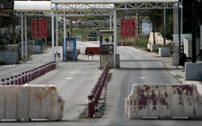 Un soldat israélien monte la garde au poste de contrôle DCO près de l'implantation de Beit El à la périphérie de la ville de Ramallah en Cisjordanie, sur une route reliant Ramallah et à Jérusalem le 1er février 2016 (Crédit : AFP / THOMAS COEX)