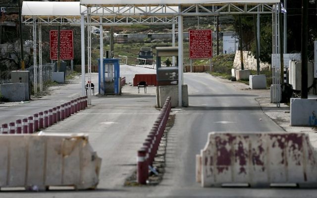 Un soldat israélien monte la garde au poste de contrôle DCO près de l'implantation de Beit El à la périphérie de la ville de Ramallah en Cisjordanie, sur une route reliant Ramallah et à Jérusalem le 1er février 2016 (Crédit : AFP / THOMAS COEX)