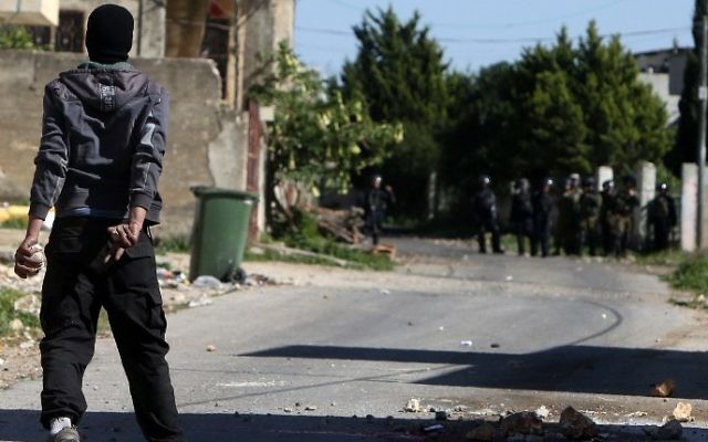 Un manifestant palestinien défie les forces de sécurité israéliennes lors d'affrontements dans le village de Kafr Qaddum, près de Naplouse, en Cisjordanie, le 11 mars 2016 (Crédit : AFP / Jaafar ASHTIYEH)