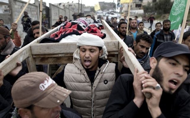 Les funérailles de deux enfants tués dans une frappe de représailles de l'armée israélienne suite à une salve de roquette tombée la veille au soir, le 12 mars 2016 à Beit Lahiya dans le nord de la bande de Gaza (Crédit : AFP / MAHMUD HAMS)