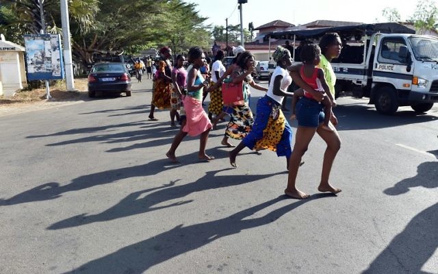 Les gens en train de fuir la plage après que des hommes lourdement armés ont ouvert le feu dans un hôtel dans la station balnéaire de Grand-Bassam en Côte d'Ivoire, le 13 mars 2016 (Crédit : AFP / ISSOUF SANOGO)
