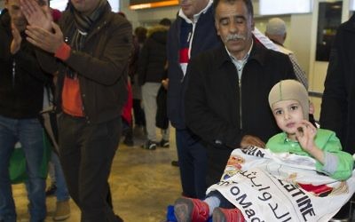 Ahmed Dawabsha, au centre, petit garçon palestinien de 5 ans qui a survécu à une attaque menée par des extrémistes juifs qui ont tué ses parents et son frère, à l'aéroport Adolfo Suarez près de Madrid, pour rencontrer les stars du Real Madrid, y compris son idole Cristiano Ronaldo, le 16 mars 2016. (Crédit : Curto de la Torre/AFP)
