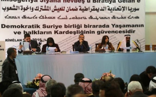 Aldar Khalil (C), du Mouvement pour une société démocratique, et le cheikh Hamad Sheikh Shihadeh (à droite), le chef du clan Naim dans le nord de la Syrie, lors d'une réunion de plus de 150 délégués kurdes, arabes, assyriens et d'autres parties dans la ville de Rmeilan, dans la province de Hasakah nord-est de la Syrie, où la décision a été prise d'établir une région fédérale, le 16 mars 2016 (Crédit : AFP / DELIL SOULEIMAN) Aldar Khalil (C), du Mouvement pour une société démocratique, et le cheikh Hamad Sheikh Shihadeh (à droite), le chef du clan Naim dans le nord de la Syrie, lors d'une réunion de plus de 150 délégués kurdes, arabes, assyriens et d'autres parties dans la ville de Rmeilan, dans la province de Hasakah nord-est de la Syrie, où la décision a été prise d'établir une région fédérale, le 16 mars 2016 (Crédit : AFP / DELIL SOULEIMAN)