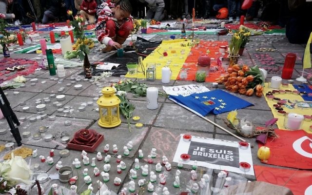 Des personnes se rassemblent pour observer une minute de silence en mémoire des victimes des attentats dans l'aéroport et le métro de Bruxelles, qui ont eu lieu un jour plus tôt, sur la Place de la Bourse dans le centre de Bruxelles, le 23 mars 2016 (Crédit : Patrik Stollarz/AFP) Des personnes se rassemblent pour observer une minute de silence en mémoire des victimes des attentats dans l'aéroport et le métro de Bruxelles, qui ont eu lieu un jour plus tôt, sur la Place de la Bourse dans le centre de Bruxelles, le 23 mars 2016 (Crédit : Patrik Stollarz/AFP)