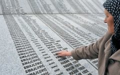 Bida Smajlovic, 64 ans, survivante du massacre de Srebrenica, au mémorial de Potocari, met le doigt sur le nom de son époux, le 24 mars 2016. (Crédit : AFP / ELVIS BARUKCIC)