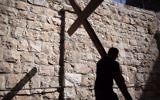 Un pèlerin catholique porte une croix de bois le long de la Via Dolorosa (chemin de la souffrance) dans la Vieille Ville de Jérusalem pendant la procession du Vendredi, le 25 mars 2016. (Crédit : Gali Tibbon / AFP)