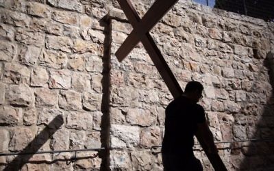 Un pèlerin catholique porte une croix de bois le long de la Via Dolorosa (chemin de la souffrance) dans la Vieille Ville de Jérusalem pendant la procession du Vendredi, le 25 mars 2016. (Crédit : Gali Tibbon / AFP)