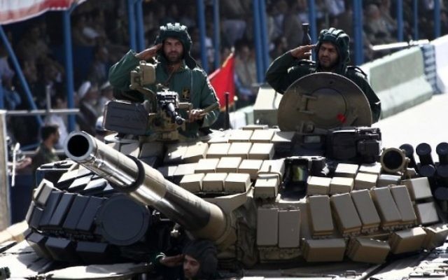 Des soldats iraniens saluent depuis un tank pendant la parade militaire annuel marquant l'anniversaire de la guerre de l'Iran contre l'Irak (1980 - 1988) à Téhéran, le 22 septembre 2014. (Crédit : Behrouz Mehri/AFP)