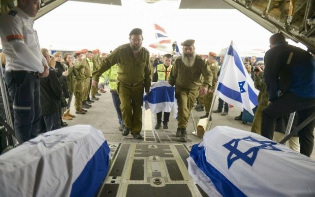 Des soldats israéliens en train de charger des cercueils transportant les corps des Israéliens tués dans un attentat suicide la veille à Istanbul dans un avion de Tsahal, le 20 mars 2016. (Crédit : unité des porte-paroles de l'armée israélienne)