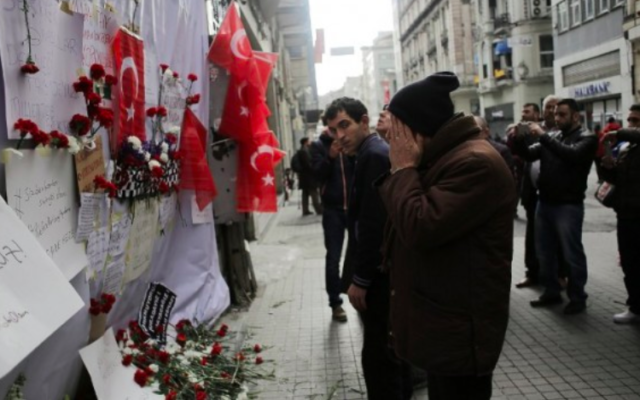 Un homme ému devant un mémorial improvisé à l'emplacement de l'explosion d'un attentat suicide dans la rue Istiklal, un quartier commerçant et touristique majeur, dans le centre d'Istanbul, le 20 mars 2016. (Crédit : AFP / Yasin Akgul) Un homme ému devant un mémorial improvisé à l'emplacement de l'explosion d'un attentat suicide dans la rue Istiklal, un quartier commerçant et touristique majeur, dans le centre d'Istanbul, le 20 mars 2016. (Crédit : AFP / Yasin Akgul)