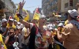 Des Palestiniens avec des affiches et des T-shirts représentant Dalal Mughrabi, une terroriste du Fatah responsable du massacre de la route côtière en 1978, qui a tué 38 Israéliens dont 13 enfants, pendant une manifestation à Ramallah, le 16 juillet 2008. (Crédit : Issam Rimawi/Flash90)