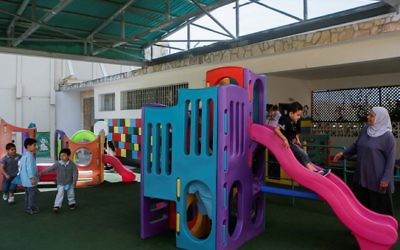 De jeunes enfants sur une aire de jeu du jardin d'enfants du couvent des sœurs comboniennes dans le quartier de Ras Al-Amud de Jérusalem est, le 19 mai 2014. (Illustration, crédit : Miriam Alster/FLASH90)