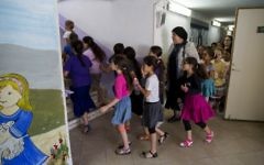 Les enfants des écoles se précipitent dans les abris alors que les sirènes sonnent partout en Israël dans le cadre d'un d'un exercice du Commandement de la Défense passive, le 2 juin 2015 (Crédit : Yonatan Sindel / Flash90)