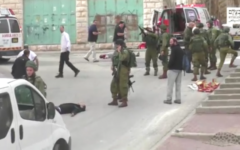 Un soldat israélien chargeant son arme avant de sembler tirer à la tête sur un terroriste palestinien au sol, apparemment désarmé, à la suite d'une attaque au couteau à Hébron, le 24 mars 2016. (Crédit : capture d'écran B'TSelem)