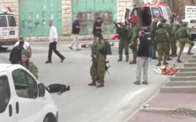 Un soldat israélien chargeant son arme avant de sembler tirer à la tête sur un terroriste palestinien au sol, apparemment désarmé, à la suite d'une attaque au couteau à Hébron, le 24 mars 2016. (Crédit : capture d'écran B'TSelem)