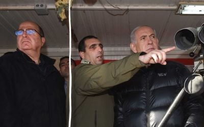Le Premier ministre Benjamin Netanyahu, à droite, Ofek Bouchris, au centre, et le ministre de la Défense Moshe Yaalon au mont Hermon, regardant la frontière israélienne avec la Syrie, le 4 février 2015. (Crédit : Effi Sharir/Pool)