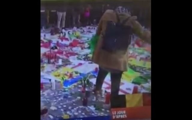 Une femme avec un hijab est vue en train d'enlever un drapeau israélien de la place de la Bourse de Bruxelles, à un mémorial improvisé après les attentats suicide qui ont tué plus de 30 personnes, le 23 mars 2016. (Crédit : capture d'écran Facebook) Une femme avec un hijab est vue en train d'enlever un drapeau israélien de la place de la Bourse de Bruxelles, à un mémorial improvisé après les attentats suicide qui ont tué plus de 30 personnes, le 23 mars 2016. (Crédit : capture d'écran Facebook)