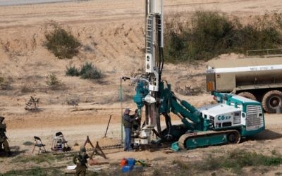 Sur cette photo d'illustration du 10 février 2016, des soldats israéliens surveillent une machine permettant de creuser des trous dans le sol côté israélien de la frontière avec la bande de Gaza pour détecter des tunnels utilisés par des groupes terroristes palestiniens qui prévoient d'attaquer Israël. (Crédit : Menahem Kahana/AFP)