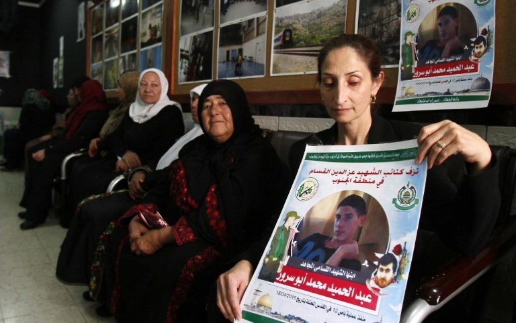 Azhar Abu Srour, la mère d'Abdel Hamid Abu Srour, 19 ans (sur l'affiche), qui a mené un attentat suicide dans un bus de Jérusalem le 18 avril, porte le deuil avec les membres de sa famille et reçoit des condoléances au centre Al-Ruwad du camp de réfugiés d'al-Ayda, le 22 avril 2016. (Crédit : AFP PHOTO / MUSA AL SHAER) Azhar Abu Srour, la mère d'Abdel Hamid Abu Srour, 19 ans (sur l'affiche), qui a mené un attentat suicide dans un bus de Jérusalem le 18 avril, porte le deuil avec les membres de sa famille et reçoit des condoléances au centre Al-Ruwad du camp de réfugiés d'al-Ayda, le 22 avril 2016. (Crédit : AFP PHOTO / MUSA AL SHAER)