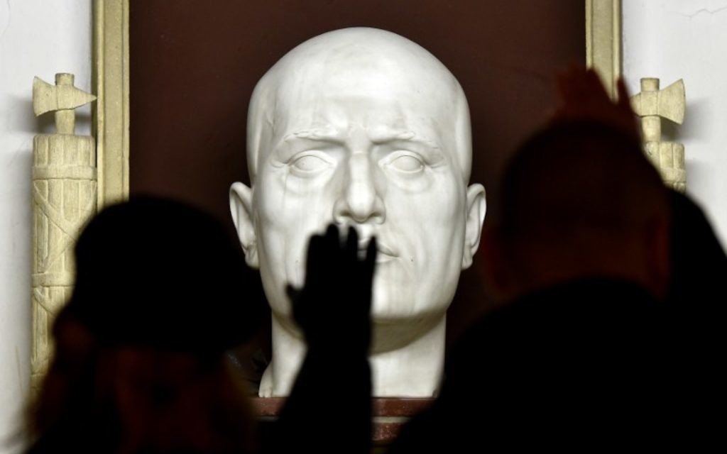 Des militants d'extrême-droite faisant le salut fasciste (salut romain) devant la tombe du dictateur italien Benito Mussolini pendant un rassemblement célébrant le dictateur à Predappio, le 24 avril 2016. Mussolini est né et a été enterré à Predappio. (Crédit : AFP Photo/Tiziana FABI) Des militants d'extrême-droite faisant le salut fasciste (salut romain) devant la tombe du dictateur italien Benito Mussolini pendant un rassemblement célébrant le dictateur à Predappio, le 24 avril 2016. Mussolini est né et a été enterré à Predappio. (Crédit : AFP Photo/Tiziana FABI)