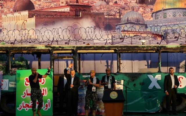 Ismail Haniyeh, du Hamas, (deuxième à gauche) participe à un rassemblement anti-israélien à Gaza-Ville, le 28 avril 2016, devant un fond dépeignant le bus de Jérusalem qui a explosé. (Crédit photo : AFP/Mohammed Abed) Ismail Haniyeh, du Hamas, (deuxième à gauche) participe à un rassemblement anti-israélien à Gaza-Ville, le 28 avril 2016, devant un fond dépeignant le bus de Jérusalem qui a explosé. (Crédit photo : AFP/Mohammed Abed)