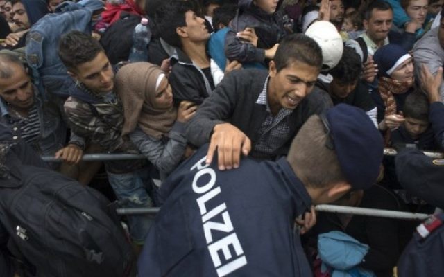 Des centaines de migrants luttent pour monter à bord d'un train à Nickelsdorf, du côté autrichien de la frontière entre l'Autriche et la Hongrie, le 11 septembre 2015. (Crédit : AFP/Joe Klamar)
