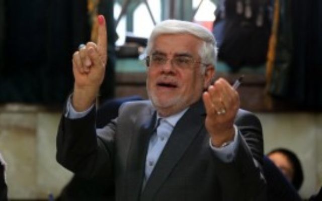 La tête de liste iranienne de la coalition réformiste pour les élections législatives de 2016, Mohammad Reza Aref, montre son doigt après avoir voté à Téhéran, le 26 février 2016. (Crédit : AFP/ATTA KENARE)