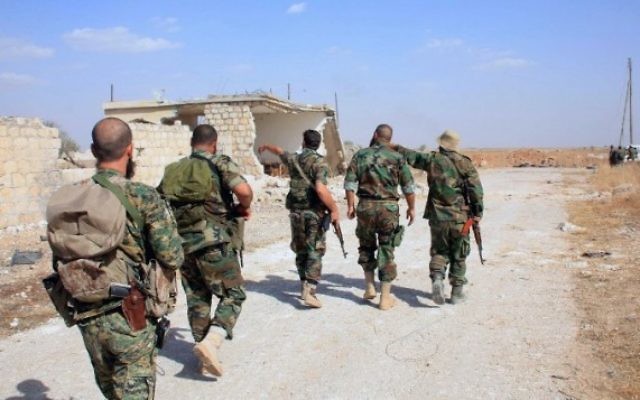 Archive : des soldats du régime syrien marchent sur une route dans une zone située autour de l'aéroport militaire Kuweires, dans la province orientale d'Alep, le 16 octobre 2015. (Crédit : AFP / George Ourfalian) Archive : des soldats du régime syrien marchent sur une route dans une zone située autour de l'aéroport militaire Kuweires, dans la province orientale d'Alep, le 16 octobre 2015. (Crédit : AFP / George Ourfalian)