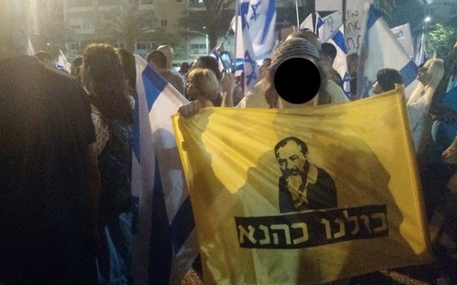 un adolescent avec un drapeau "Nous sommes tous Kahane" pendant un rassemblement de soutien à un soldat accusé d'avoir tué un attaquant palestinien neutralisé en mars à Hébron, le 19 avril 2016. (Crédit : Judah Ari Gross/Times of Israel) un adolescent avec un drapeau "Nous sommes tous Kahane" pendant un rassemblement de soutien à un soldat accusé d'avoir tué un attaquant palestinien neutralisé en mars à Hébron, le 19 avril 2016. (Crédit : Judah Ari Gross/Times of Israel)