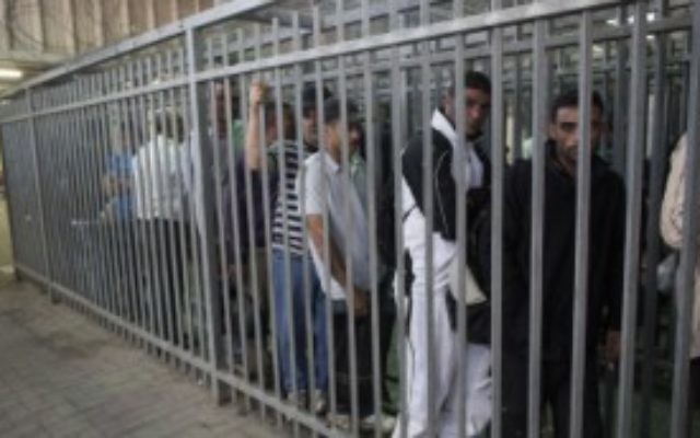 Des travailleurs palestiniens attendent pour passer un checkpoint depuis la ville de Ramallah, en Cisjordanie, vers Israël, le 4 juin 2013. (Crédit photo : Yonatan Sindel/Flash90)