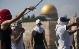 Des Palestiniens jetant des pierres sur des policiers israéliens (non visibles) à Jérusalem Est (Crédit : Yonatan Sindel/Flash90)