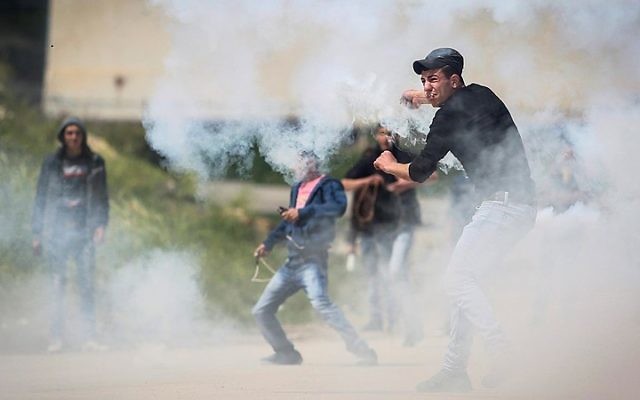 Des Palestiniens manifestent devant les forces de sécurité israéliennes pendant la "Journée de la Terre", devant la prison Ofer, gérée par les Israéliens, près de Betunia, en Cisjordanie, le 30 mars 2016. (Crédit : Flash90)